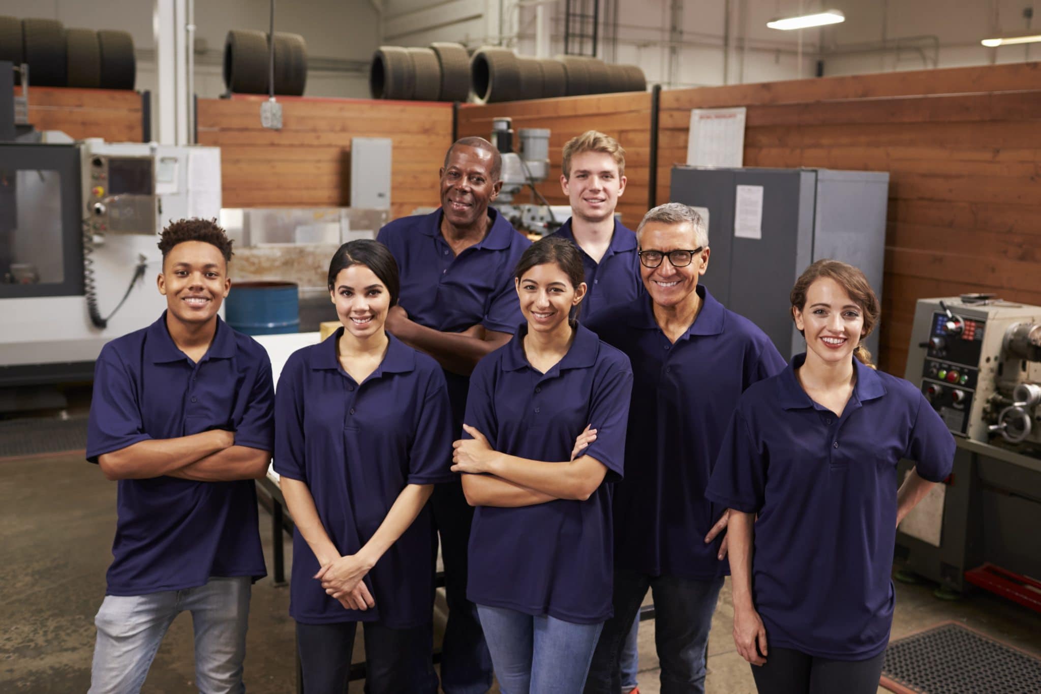 Portrait Of Engineers And Apprentices In Busy Factory - Cleaning services |Â Upkeep Maintenance